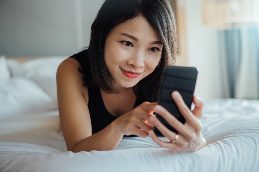 cheerful young beautiful woman using smart phone on royalty free image 1701876409